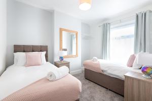 斯旺西The Place to Yourself - Swansea City的一间卧室设有两张床和窗户。
