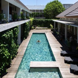 外南梦布拉姆班甘酒店的在房子里游泳池游泳的人