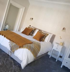 福克兰盟约酒店的卧室配有一张白色的大床和一张桌子