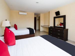阿卡普尔科Capital O Hotel Los Caracoles, Acapulco的酒店客房,设有两张床和镜子