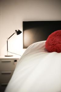 蒙得维的亚Rentline Apartamentos - Sunline的红色枕头坐在床上,带灯