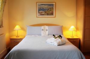 巴德利索尔特顿长程酒店的卧室配有一张白色的床,上面有两只填充动物