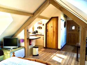 斯通豪斯Greencourt Loft - The Cotswold Way, Stroud的阁楼间配有床和电视