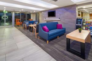 圣安娜奥兰治县机场拉拉库塔酒店的一间设有蓝色沙发和桌子的等候室