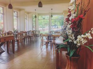 克拉鲁河畔卡尔穆Pousada Pontal do Lago的一间餐厅,在房间内摆放着桌椅和鲜花