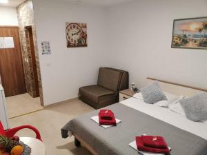 巴什卡沃达Villa Šimović的一间卧室配有一张带椅子的床和一张红色的壁画