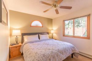 埃斯蒂斯帕克Woodlands on Fall River的一间卧室配有一张带吊扇和窗户的床。
