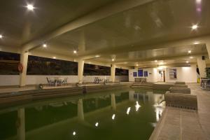 派帕索查格塔阿科斯塔酒店的一座配有桌椅的建筑里的水池