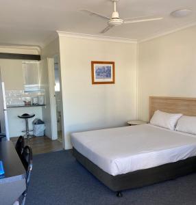 赫维湾赫维湾汽车旅馆的卧室配有白色的床、桌子和天花板