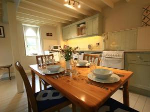 PristonCider Press Cottage的厨房配有带盘子和玻璃杯的木桌