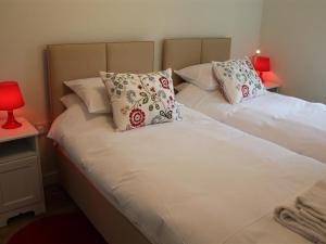 沙夫茨伯里The Milking Parlour的一间卧室配有两张带枕头和红灯的床