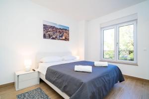 杜布罗夫尼克Apartment 'Holiday Above Dubrovnik'的白色的卧室设有床和窗户