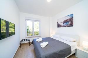 杜布罗夫尼克Apartment 'Holiday Above Dubrovnik'的一间卧室配有一张床,上面有两条毛巾