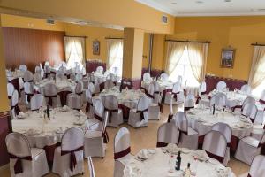 马拉加Hotel Romerito的宴会厅配有白色的桌椅