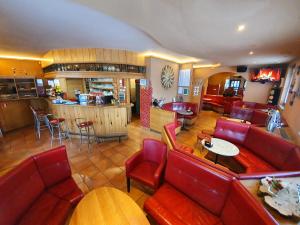 新梅斯托诺瓦克旅舍的一间设有红色皮革座椅的餐厅和一间酒吧