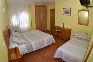 瓜尔多蒙塔尼亚帕伦蒂娜酒店的一间卧室配有两张床、一张桌子和一面镜子