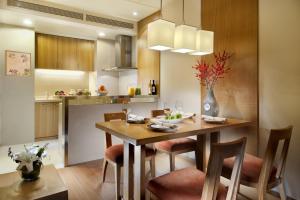 天津天津盛捷国际大厦服务公寓的厨房以及带木桌和椅子的用餐室。