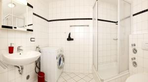 因塞尔波埃尔Strandglück的白色的浴室设有水槽和淋浴。