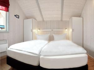 KaltenhofDänisches Ferienhaus的一张带两个枕头的大白色床