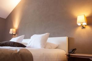 格朗当拉帕瑟里尔酒店的一间卧室配有带白色枕头和2盏灯的床。