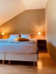 格朗当拉帕瑟里尔酒店的一间卧室配有一张带蓝色床单的床和两盏灯。