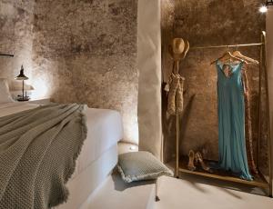 费拉Winery Hotel 1870的卧室挂在墙上,连着连衣裙