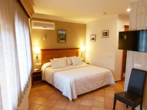 马斯萨内特-德卡夫雷尼斯拉夸德拉酒店及餐厅的配有一张床和一把椅子的酒店客房
