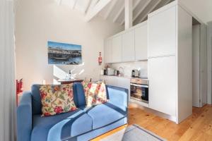 波尔图AmaOporto - St. Ildefonso的一间带蓝色沙发的客厅和一间厨房