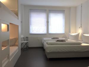 柏林BNB near Brandenburg Gate - Rooms & Apartments的白色客房的两张床,设有两扇窗户