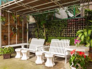 曼谷帕同望酒店的庭院里设有三把白色椅子和一张桌子