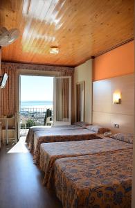 罗萨斯格蕾斯酒店的酒店客房设有两张床和大窗户。