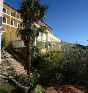 罗萨斯格蕾斯酒店的前面有棕榈树的建筑