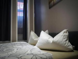 柏林Amaya Motel的卧室配有一张带白色枕头的床,卧室设有窗户