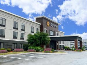奥尔巴尼La Quinta Inn & Suites by Wyndham-Albany GA的前面有一个停车位的酒店