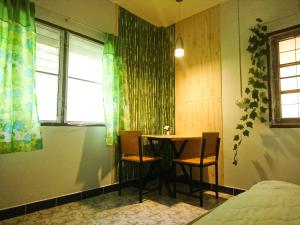 邦涛海滩H&Q Bangtao Rooms的客房设有桌子、两把椅子和窗户。