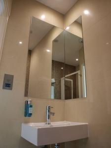伦敦简朴客房&套房酒店的一间带水槽和镜子的浴室