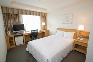 八王子市八王子京王广场酒店的酒店客房配有一张床、一张书桌和一台电视。