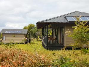 安加罗阿Maunga Roa Eco Lodge的屋顶上设有太阳能电池板的小房子