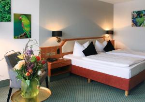 雷根斯堡AVIA酒店的配有一张床和花瓶的酒店客房