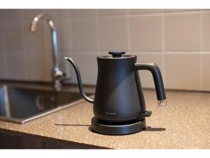 福冈Hotel Great Morning的厨房柜台上的黑色咖啡壶