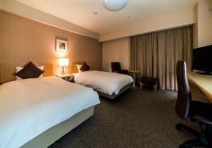 秋田大和鲁内秋田酒店的酒店客房配有两张床和一张书桌