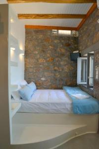 SchinopiLefteris Home的一间卧室设有一张床和石墙