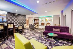 埃尔克哈特La Quinta Inn and Suites by Wyndham Elkhart的大堂设有紫色的沙发和椅子,酒吧