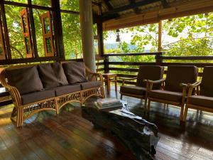 芙蓉Langit Rimba Resort的客厅配有沙发和两把椅子