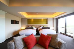 富士河口湖里贾纳河口湖酒店的酒店的客房 - 带两张床和一张带红色枕头的沙发