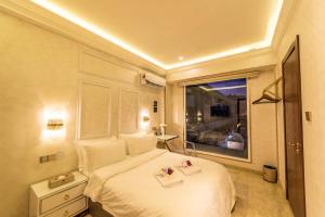 哥打京那巴鲁AC Residence - Behind Cititel Hotel的卧室配有白色的床和窗户。
