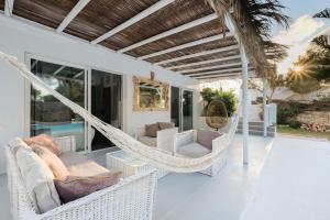 圣埃乌拉利亚Villa Clara Ibiza的房屋内带吊床和椅子的门廊
