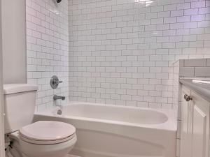 温哥华莉莉小屋的白色的浴室设有卫生间和浴缸。