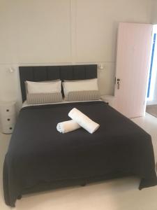 拜伦湾拜伦泉酒店的一张黑色的床,上面有两条可移动的毛巾
