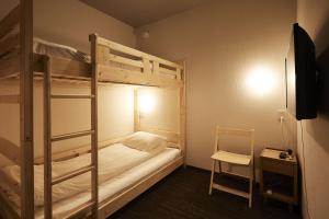 大阪HOTEL THE ROCK的一间卧室配有两张双层床和椅子